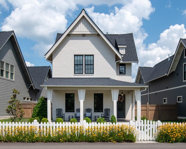 2618 Buckner Ln, Thompsons Station, TN 37179 - view of front facade featuring a porch, brick siding, a fenced front yard, and a shingled roof