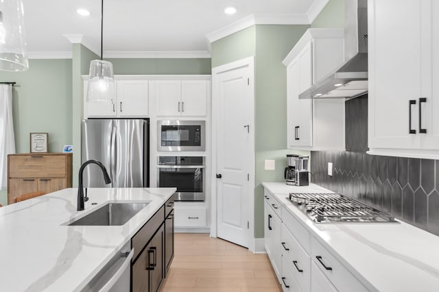 2618 Buckner Ln, Thompsons Station, TN 37179 - kitchen with appliances with stainless steel finishes, wall chimney range hood, white cabinetry, ornamental molding, and tasteful backsplash