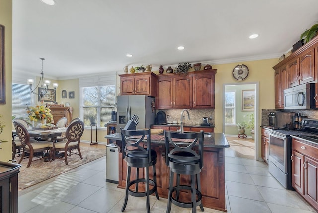 973 Rip Steele Rd, Columbia, TN 38401 - kitchen featuring appliances with stainless steel finishes, light tile patterned flooring, tasteful backsplash, a center island with sink, and crown molding