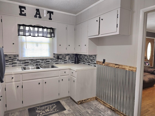 5840 Scottsville Rd, Lafayette, TN 37083 - kitchen featuring a textured ceiling, crown molding, white cabinets, decorative backsplash, and light wood finished floors