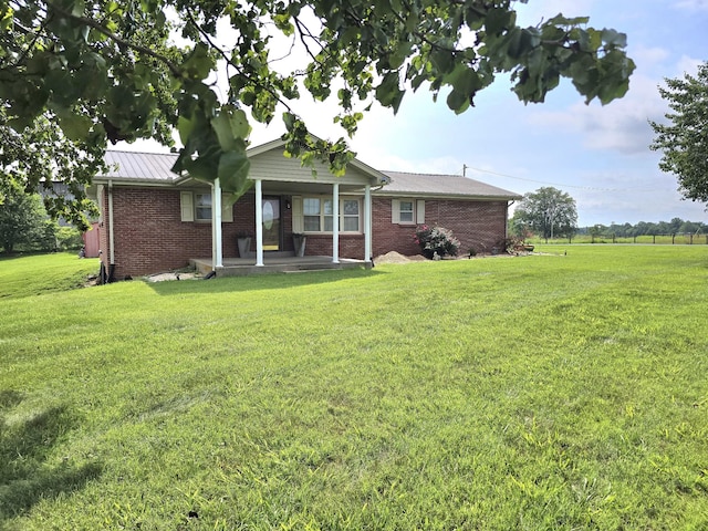 5840 Scottsville Rd, Lafayette, TN 37083 - rear view of property featuring a lawn, brick siding, and covered porch