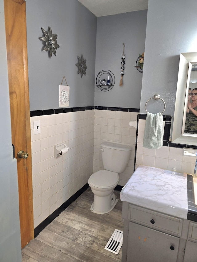 5840 Scottsville Rd, Lafayette, TN 37083 - bathroom with wood finished floors, tile walls, vanity, and a wainscoted wall