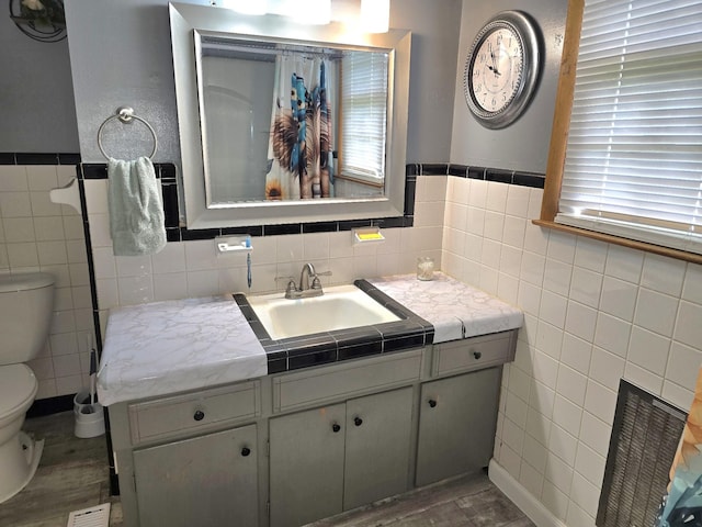 5840 Scottsville Rd, Lafayette, TN 37083 - bathroom featuring tile walls, vanity, wood finished floors, and a wainscoted wall