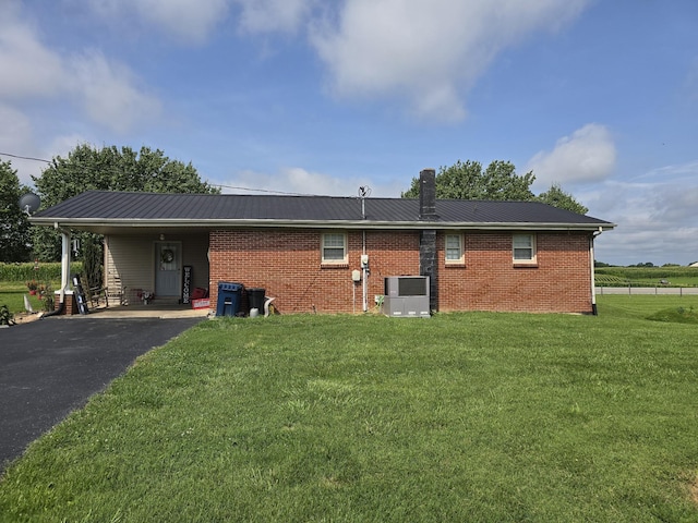 5840 Scottsville Rd, Lafayette, TN 37083 - view of side of home with driveway, an attached carport, a lawn, a metal roof, and brick siding