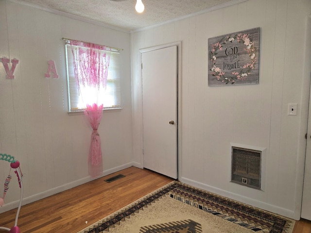 5840 Scottsville Rd, Lafayette, TN 37083 - foyer featuring wood finished floors, crown molding, heating unit, wood walls, and a textured ceiling