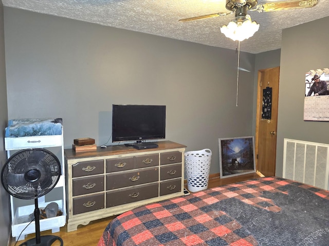 5840 Scottsville Rd, Lafayette, TN 37083 - bedroom featuring a textured ceiling, a ceiling fan, and wood finished floors