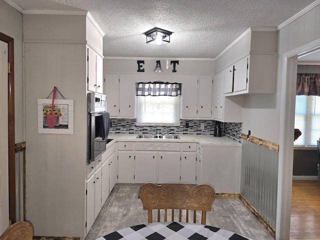 5840 Scottsville Rd, Lafayette, TN 37083 - kitchen featuring light wood-style floors, light countertops, decorative backsplash, ornamental molding, and a textured ceiling