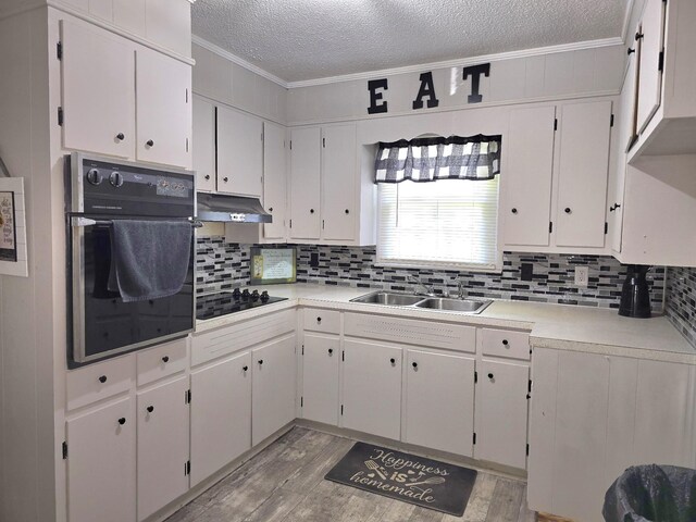5840 Scottsville Rd, Lafayette, TN 37083 - kitchen featuring oven, a textured ceiling, crown molding, black electric cooktop, and light wood-style flooring