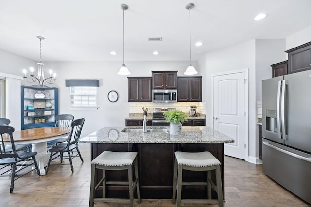2426 Telford Ln, Murfreesboro, TN 37128 - kitchen featuring stainless steel appliances, a chandelier, dark brown cabinetry, decorative backsplash, and dark wood-style flooring