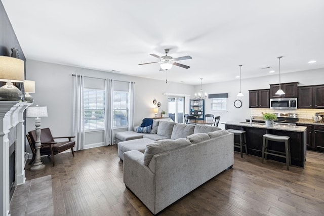 2426 Telford Ln, Murfreesboro, TN 37128 - living area with a ceiling fan, a fireplace with flush hearth, dark wood-style flooring, recessed lighting, and a chandelier