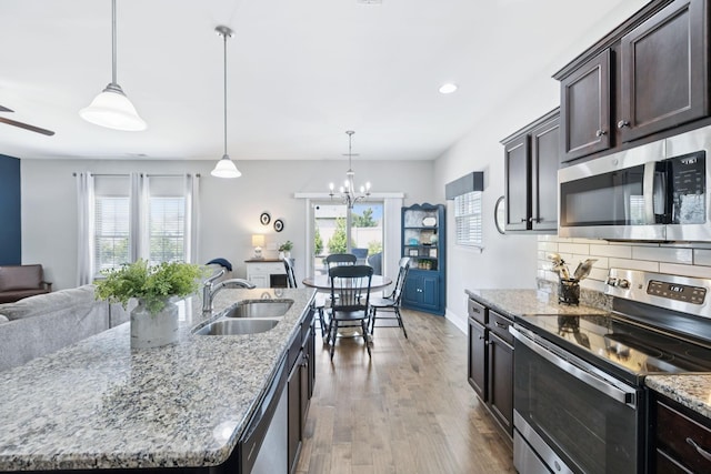 2426 Telford Ln, Murfreesboro, TN 37128 - kitchen featuring appliances with stainless steel finishes, dark brown cabinetry, open floor plan, healthy amount of natural light, and recessed lighting