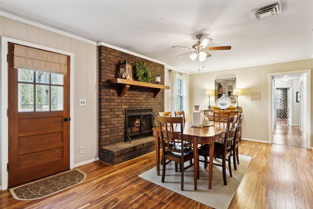6002 Temple Rd, Nashville, TN 37221 - dining area featuring crown molding, healthy amount of natural light, a ceiling fan, a brick fireplace, and wood finished floors