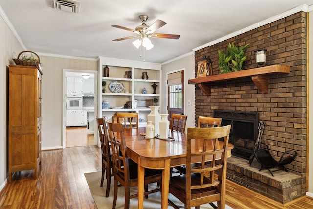 6002 Temple Rd, Nashville, TN 37221 - dining area featuring hardwood / wood-style floors, ceiling fan, crown molding, and a fireplace