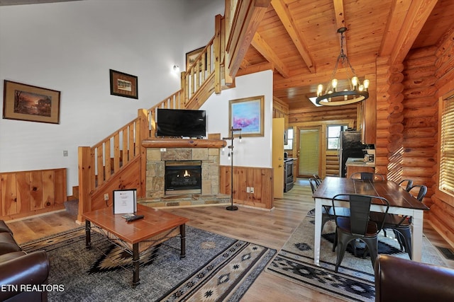 849 Golf View Blvd, Pigeon Forge, TN 37863 - living room featuring stairs, log walls, light wood finished floors, a chandelier, and a high ceiling