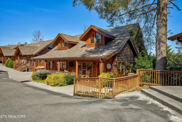 849 Golf View Blvd, Pigeon Forge, TN 37863 - view of front facade with log siding, a porch, and a shingled roof