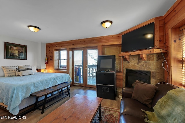 849 Golf View Blvd, Pigeon Forge, TN 37863 - bedroom featuring access to exterior, wood finished floors, wood walls, and a fireplace