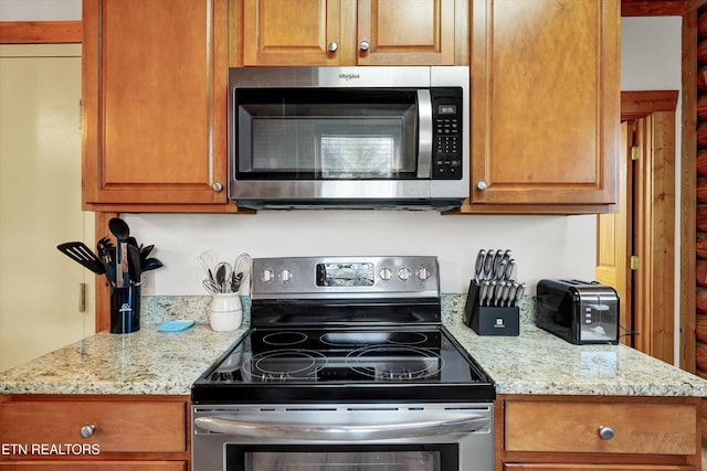 849 Golf View Blvd, Pigeon Forge, TN 37863 - kitchen featuring stainless steel appliances, light stone counters, and brown cabinets