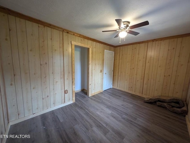 1014 Frank Campbell Rd, Jamestown, TN 38556 - unfurnished bedroom with wood walls, dark wood-style floors, ceiling fan, and a textured ceiling