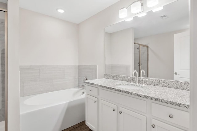 708 Ellie Dr, Madison, TN 37115 - bathroom featuring vanity, a garden tub, a stall shower, and wood finished floors