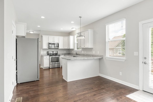 708 Ellie Dr, Madison, TN 37115 - kitchen featuring stainless steel appliances, a peninsula, dark wood-type flooring, white cabinetry, and recessed lighting