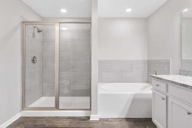 708 Ellie Dr, Madison, TN 37115 - bathroom featuring vanity, a bath, wood finish floors, a shower stall, and recessed lighting