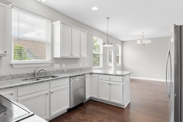 708 Ellie Dr, Madison, TN 37115 - kitchen with stainless steel appliances, a peninsula, white cabinets, dark wood-style floors, and a chandelier