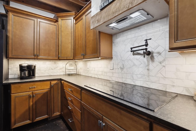 223 Kennett Rd, Old Hickory, TN 37138 - kitchen with black electric cooktop, extractor fan, backsplash, dark countertops, and brown cabinetry