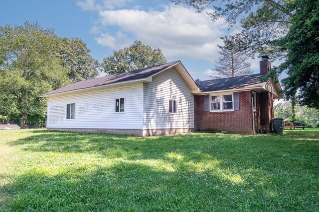 1539 Old Florence Rd, Lawrenceburg, TN 38464 - view of home's exterior with a chimney, a lawn, and brick siding