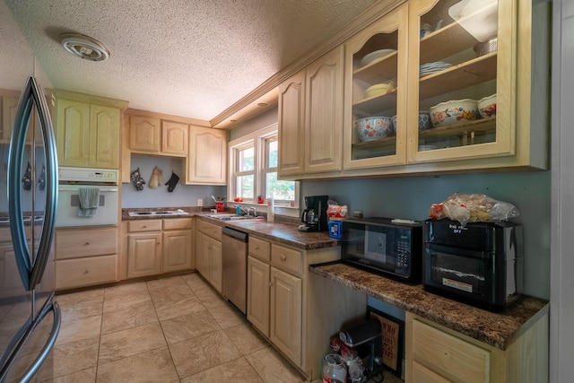 1539 Old Florence Rd, Lawrenceburg, TN 38464 - kitchen with appliances with stainless steel finishes, a textured ceiling, light brown cabinetry, and glass insert cabinets