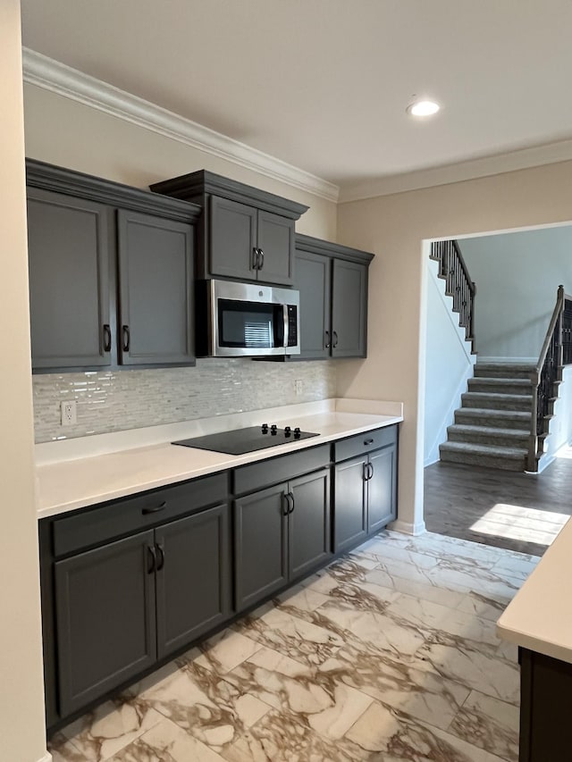 1775 Oak Forest Dr, Clarksville, TN 37043 - kitchen featuring stainless steel microwave, black electric cooktop, crown molding, tasteful backsplash, and light countertops