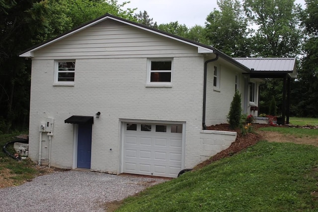 762 Austin Bottom Rd, Baxter, TN 38544 - view of home's exterior featuring an attached garage, brick siding, gravel driveway, and a yard
