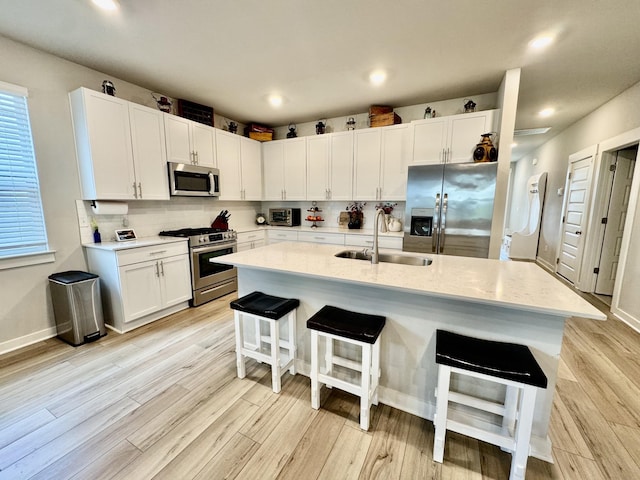 1229 Inverness Pass, Lebanon, TN 37087 - kitchen with stainless steel appliances, light wood-style flooring, a kitchen breakfast bar, white cabinets, and recessed lighting