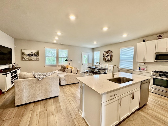 1229 Inverness Pass, Lebanon, TN 37087 - kitchen featuring stainless steel appliances, open floor plan, light wood-style floors, white cabinetry, and recessed lighting
