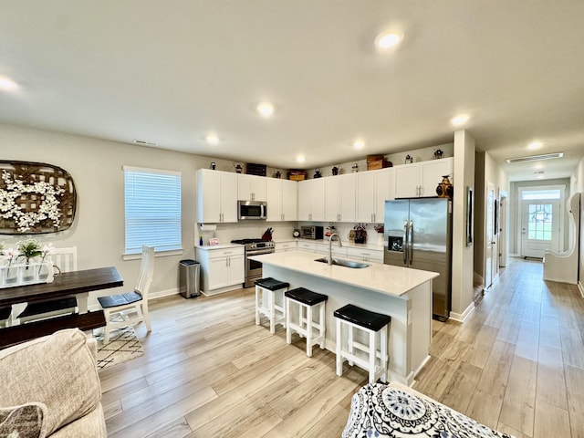 1229 Inverness Pass, Lebanon, TN 37087 - kitchen with appliances with stainless steel finishes, a breakfast bar area, light countertops, light wood-style floors, and recessed lighting