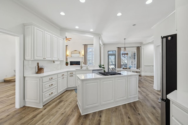8217 W Chase Ct, Nashville, TN 37221 - kitchen with crown molding, stainless steel appliances, light countertops, white cabinets, and recessed lighting