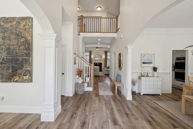 8217 W Chase Ct, Nashville, TN 37221 - foyer with ornate columns, arched walkways, a ceiling fan, wood finished floors, and a high ceiling