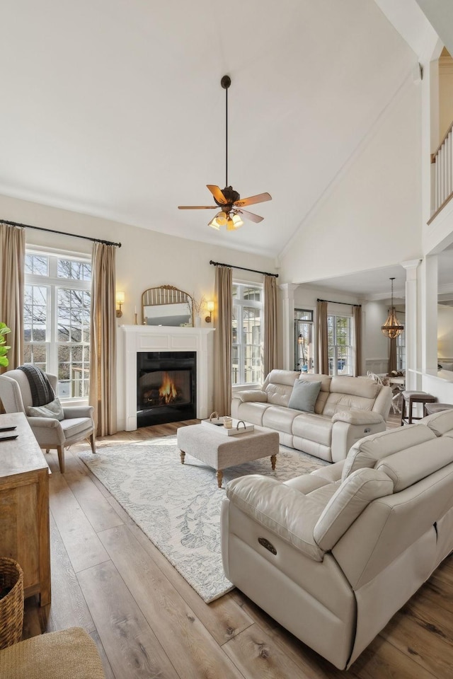 8217 W Chase Ct, Nashville, TN 37221 - living area with ceiling fan, wood finished floors, a glass covered fireplace, decorative columns, and high vaulted ceiling