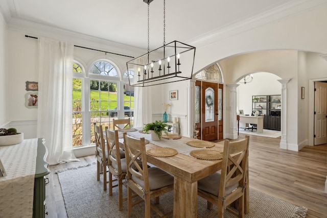 8217 W Chase Ct, Nashville, TN 37221 - dining area with arched walkways, ornate columns, crown molding, wood finished floors, and a chandelier