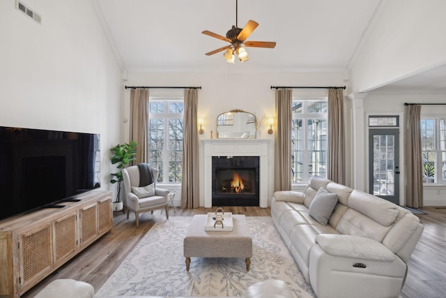 8217 W Chase Ct, Nashville, TN 37221 - living room with vaulted ceiling, crown molding, a warm lit fireplace, wood finished floors, and ceiling fan