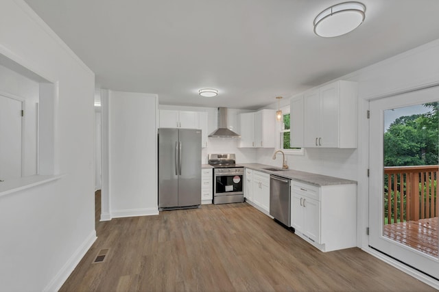 4921 Shihmen Dr, Antioch, TN 37013 - kitchen with appliances with stainless steel finishes, wall chimney range hood, light wood-style floors, backsplash, and light countertops