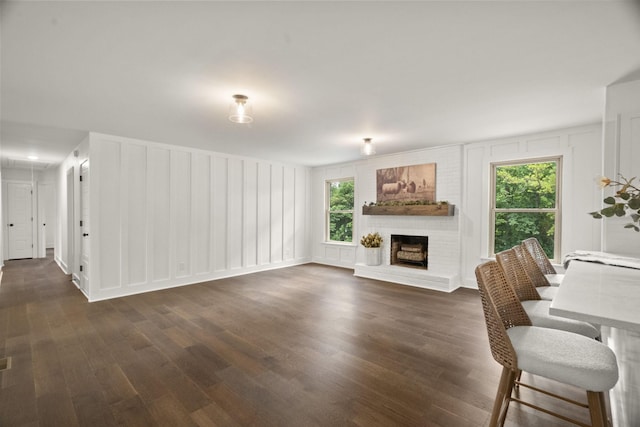 5670 Lakeview Rd, Springfield, TN 37172 - unfurnished living room featuring a decorative wall, dark wood-style flooring, and a brick fireplace