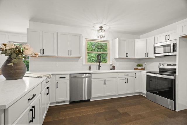5670 Lakeview Rd, Springfield, TN 37172 - kitchen featuring appliances with stainless steel finishes, backsplash, light countertops, dark wood-style flooring, and white cabinetry