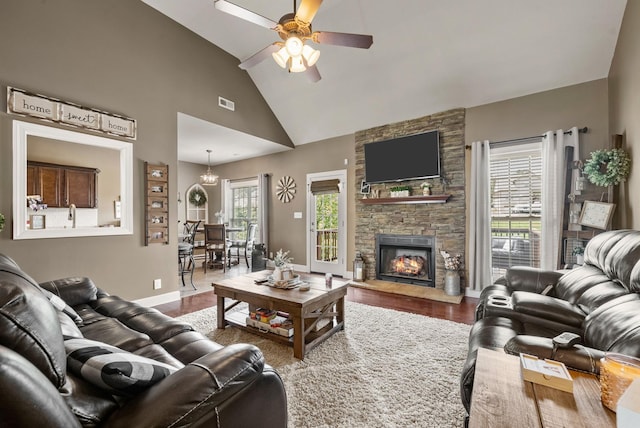 1192 Wicke Rd, Adams, TN 37010 - living room featuring wood finished floors, a ceiling fan, high vaulted ceiling, a fireplace, and a chandelier
