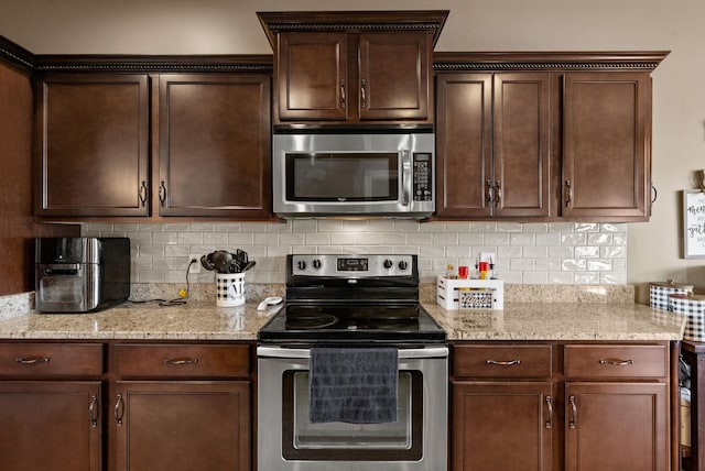 1192 Wicke Rd, Adams, TN 37010 - kitchen with appliances with stainless steel finishes, dark brown cabinetry, backsplash, and light stone countertops