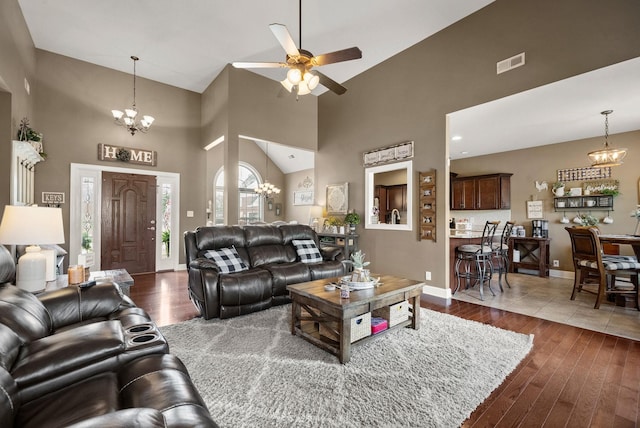 1192 Wicke Rd, Adams, TN 37010 - living area featuring high vaulted ceiling, dark wood-style flooring, ceiling fan, and a chandelier