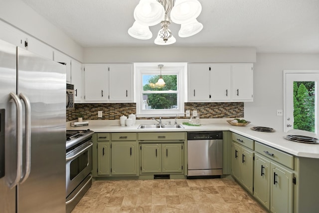 215 Patrick St, Estill Springs, TN 37330 - kitchen with stainless steel appliances, green cabinetry, a chandelier, and light countertops