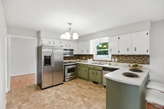 215 Patrick St, Estill Springs, TN 37330 - kitchen with stainless steel appliances, green cabinetry, a chandelier, a peninsula, and tasteful backsplash