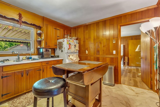 1011 S Baird Ln, Murfreesboro, TN 37130 - kitchen featuring wood walls, light countertops, freestanding refrigerator, crown molding, and brown cabinets