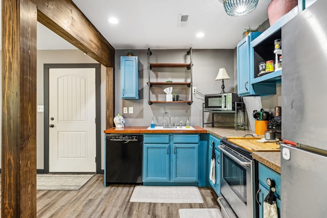 140 Cane Creek Rd, Hohenwald, TN 38462 - kitchen with stainless steel appliances, blue cabinets, open shelves, and light wood-type flooring