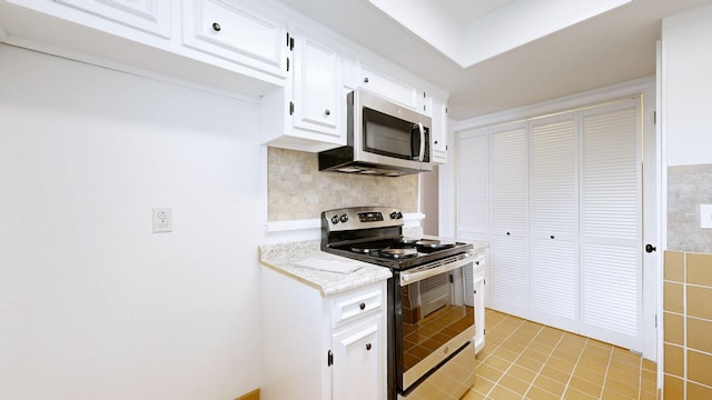 1002 E Northfield Blvd Unit G105, Murfreesboro, TN 37130 - kitchen featuring appliances with stainless steel finishes, white cabinets, light tile patterned flooring, and backsplash